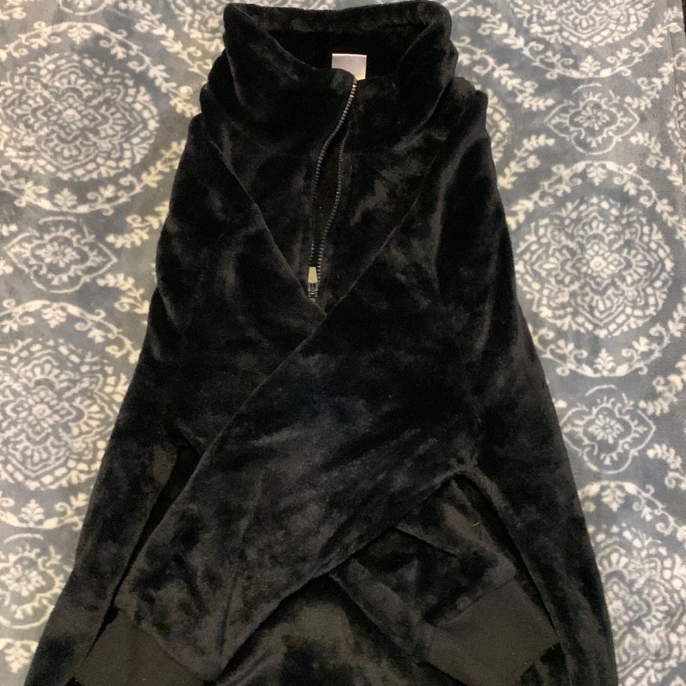 A black jacket that is fluffy and has a half zip up